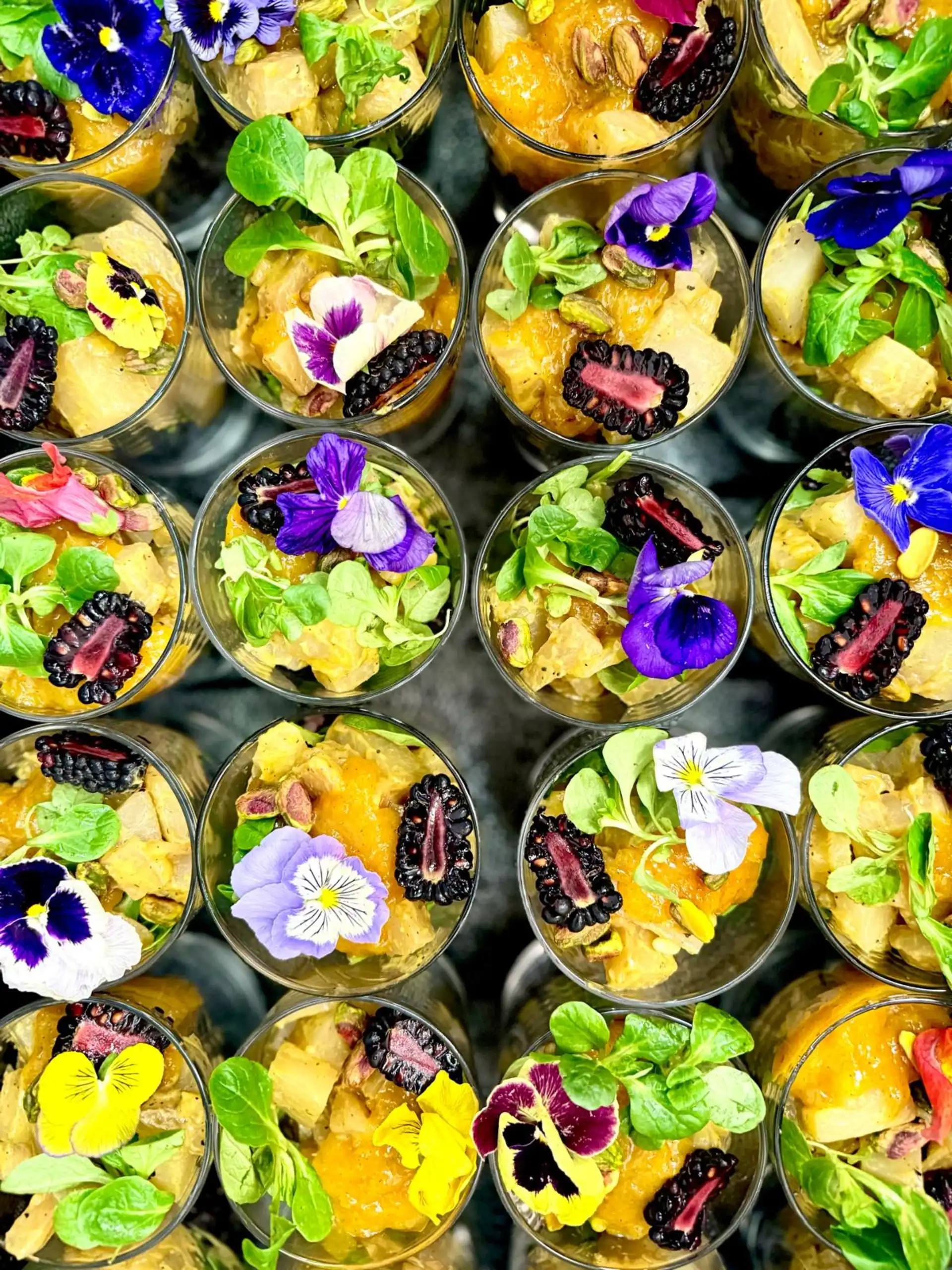 Bunte vegetarische Gerichte im Glas mit essbaren Blüten – Firmencatering Dortmund